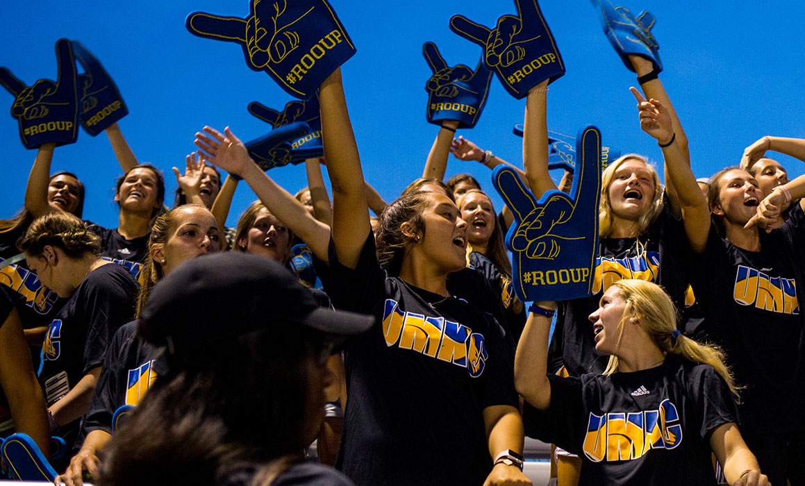 A group of UMKC students cheer excitedly and loudly at a UMKC men's soccer game.