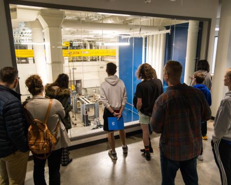 students watch robotic arms work in a clean room during biomedical engineering day