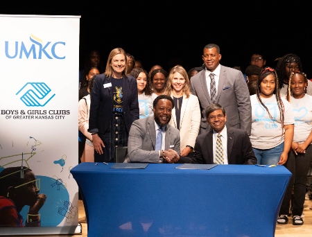 The UMKC chancellor shakes hands with Boys and Girls Club representative at announcement of the partnership