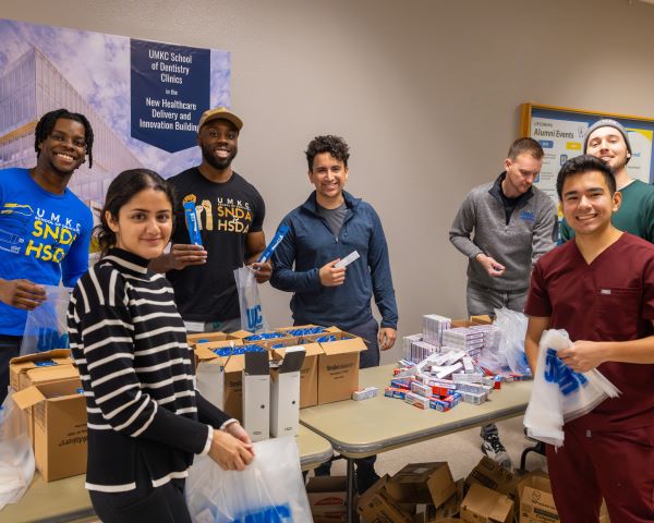Group of dentistry students look please as they pack dental hygiene packs for their Martin Luther King Jr Day of Service