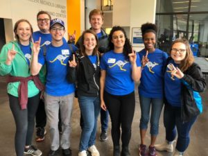 Group of students give Roo Up hand gesture during Roos Give Back.