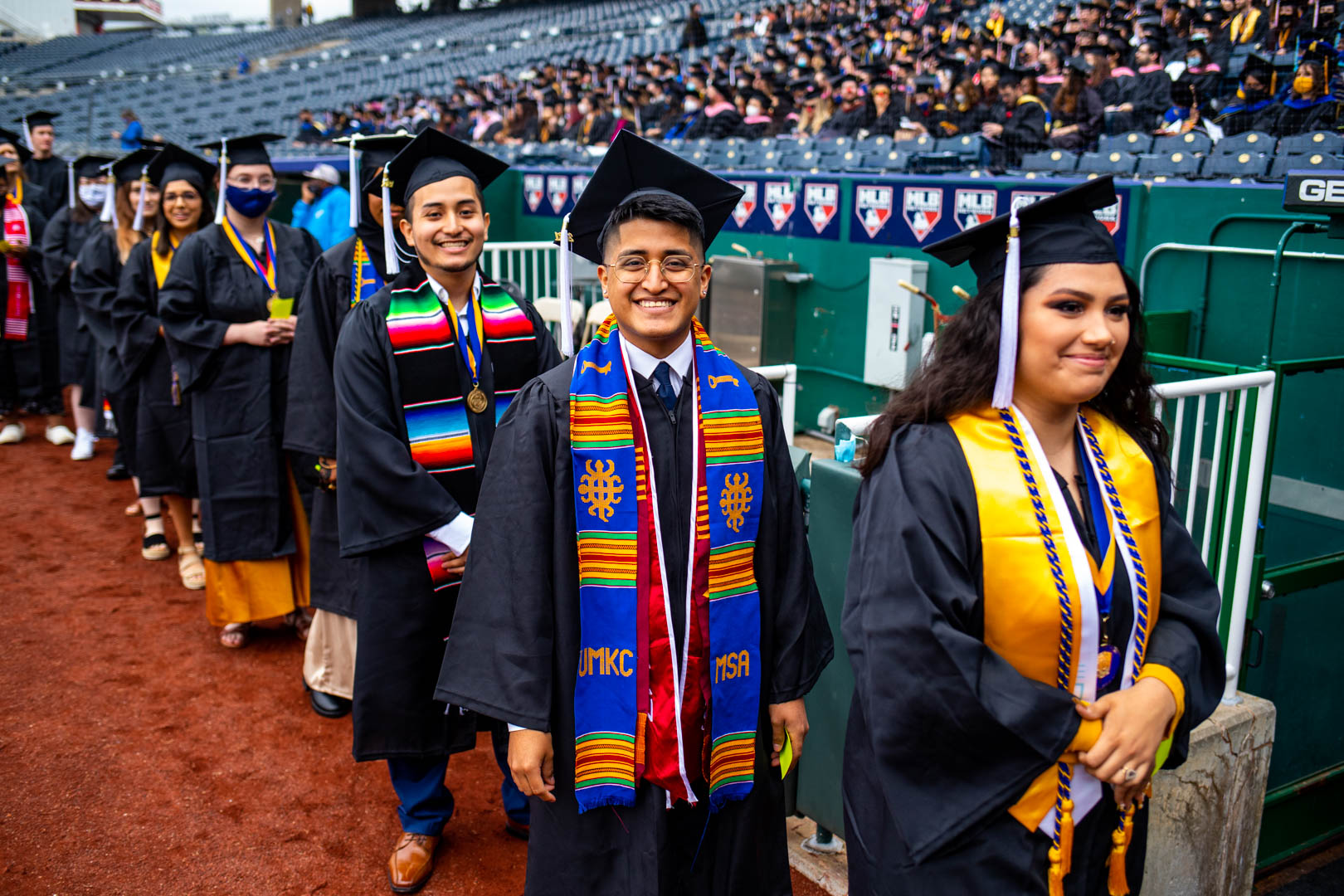 graduates wearing cap and gown line up for the procession at the 2021 UMKC commencement