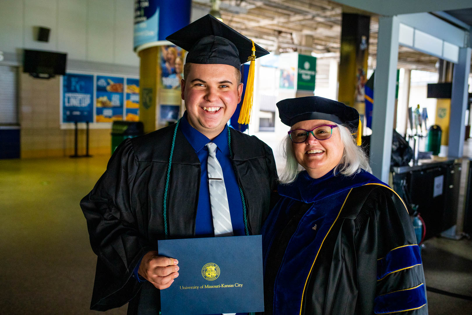 an undergraduate student poses with a graduate student at the commencement at the K