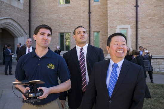 Travis Fields, left, assistant professor of engineering and UMKC’s drone guru, pilots a drone while Caruso and Mun Choi, UM System president, check it out.