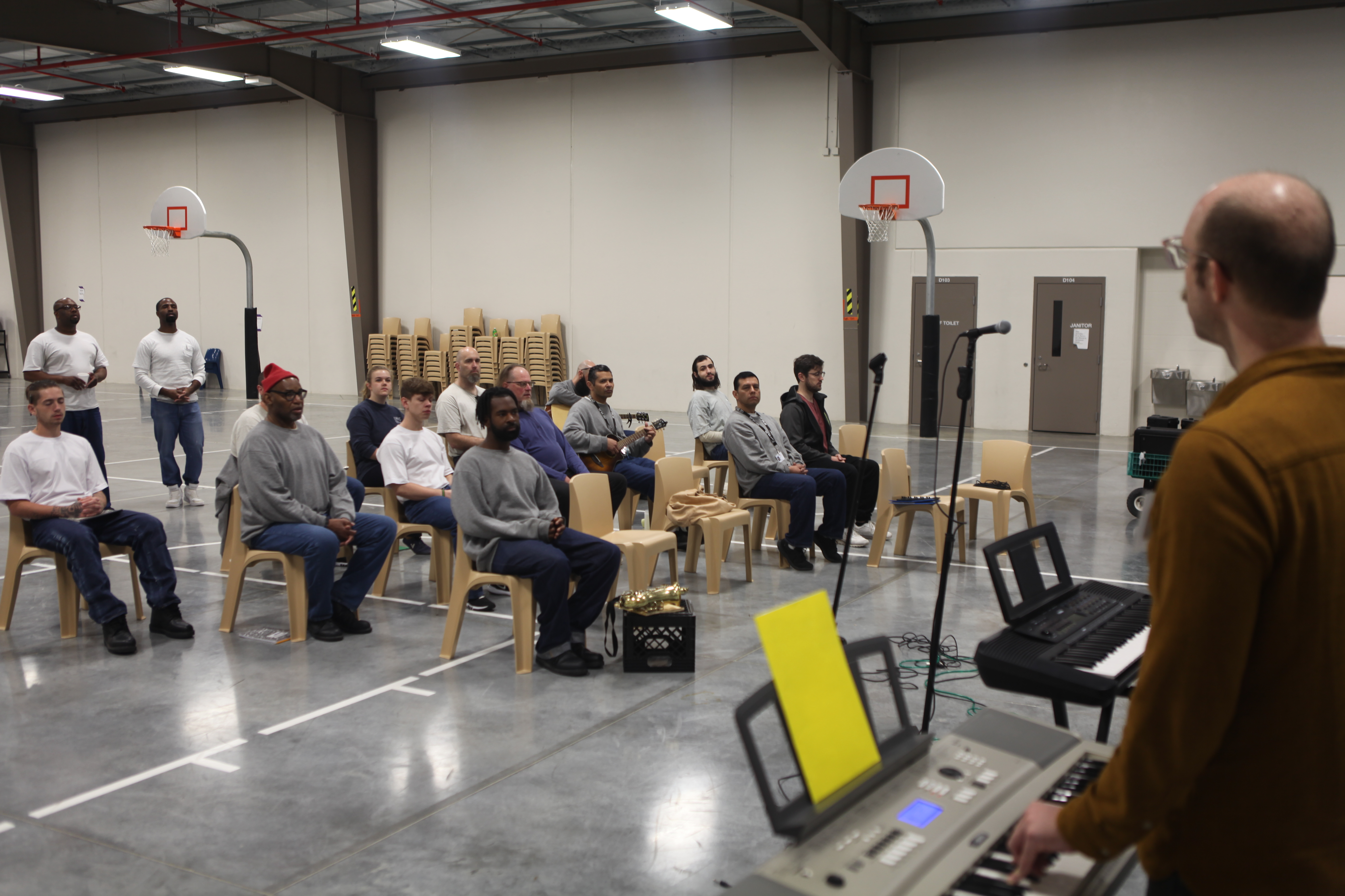 Incarcerated prisoners preparing to perform and compose music. 