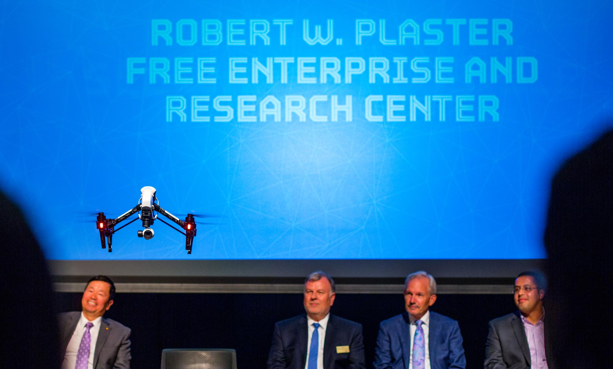 drone hovers over the stage at the research center announcement event