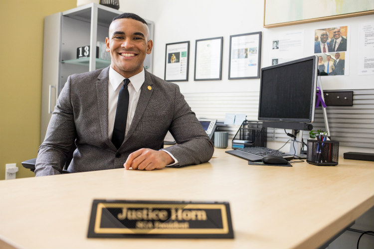 UMKC Student President Justice Horn sitting at his desk.