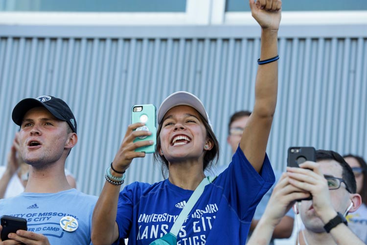 students cheer and take photos at the women's soccer game