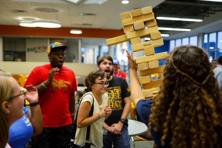 Students are surprised as their giant Jenga tower starts to fall