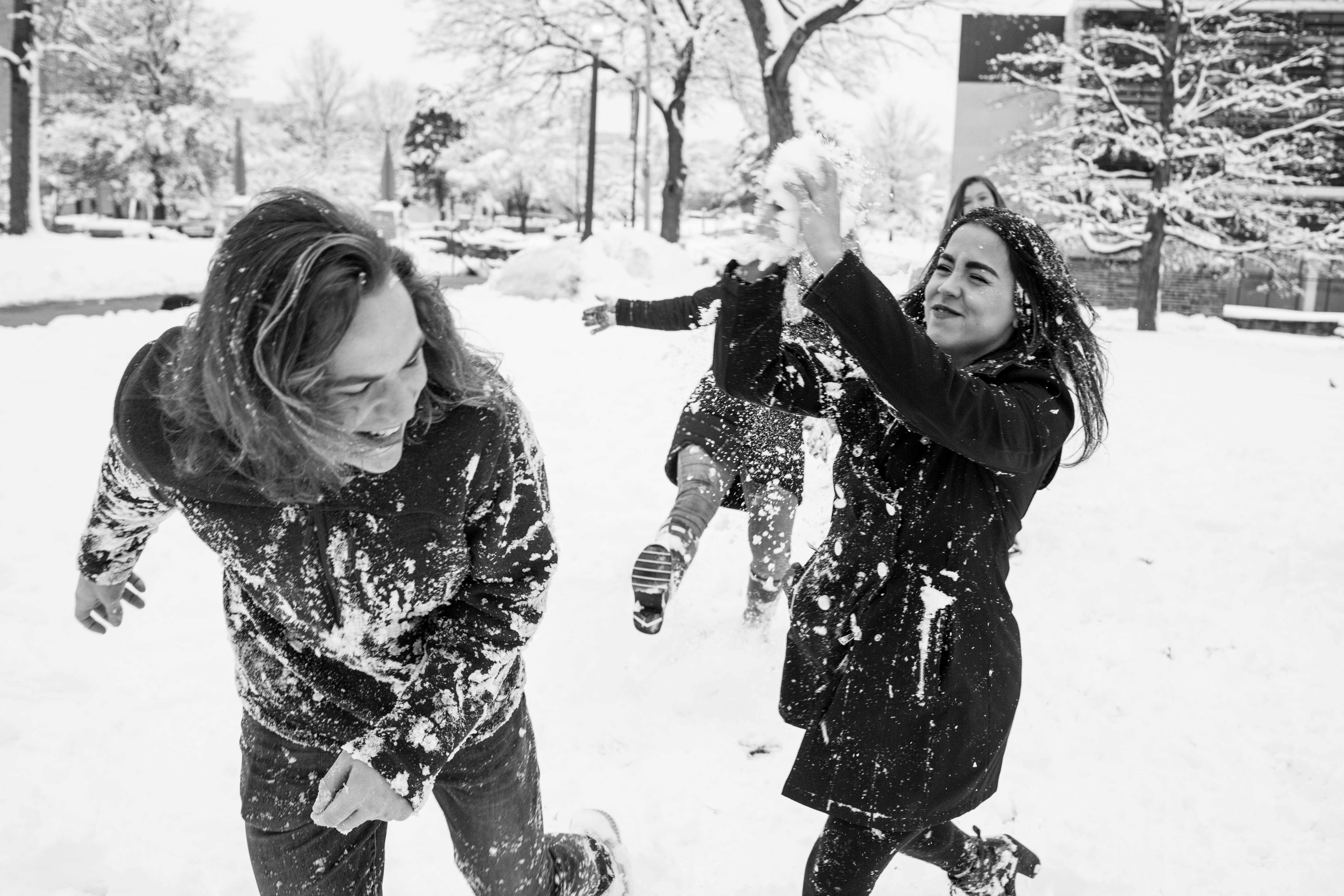 A black and white photograph of UMKC students in a snowball fight.
