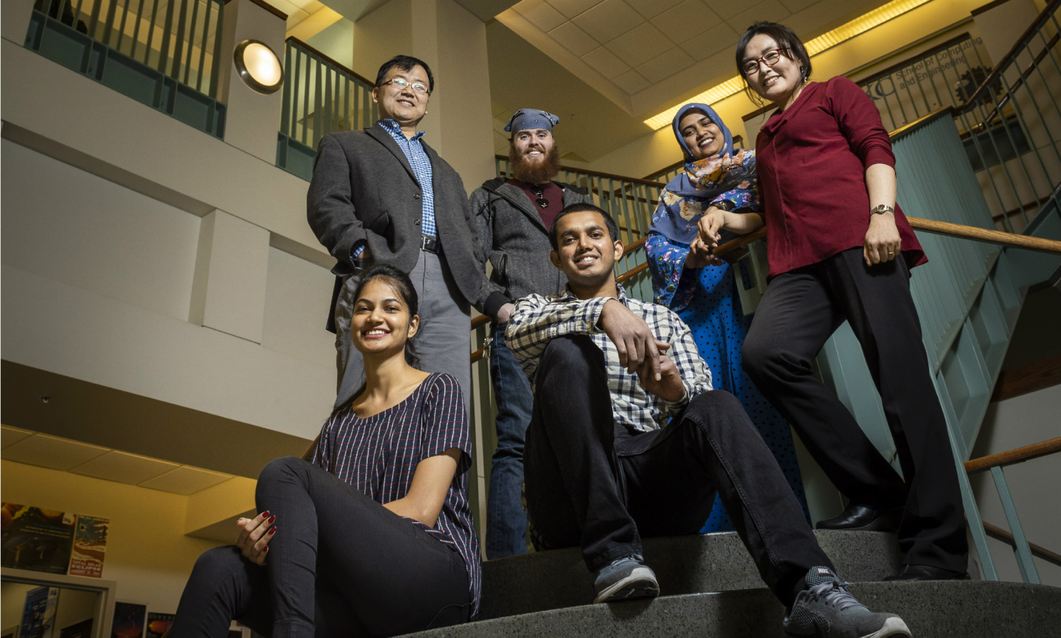 photo of team sitting and standing on stairs inside engineering building