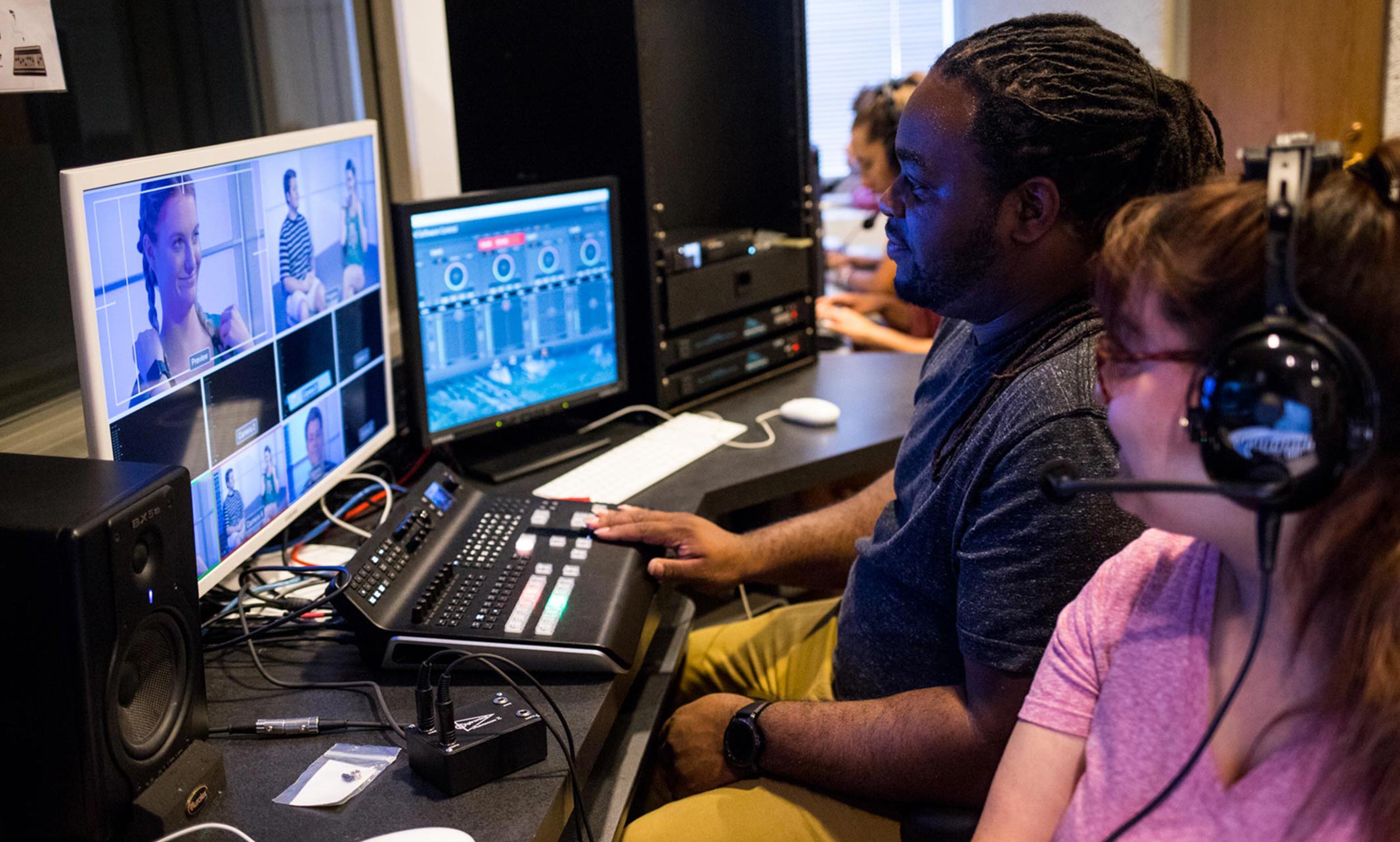 Two students working at a video editing bay