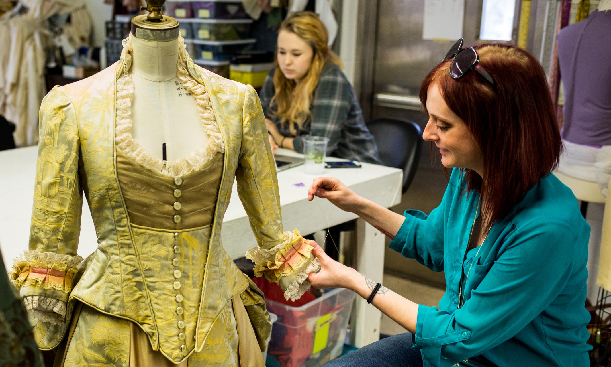  Graduate student L.A. Clevenson works on the finishing details of a dress.