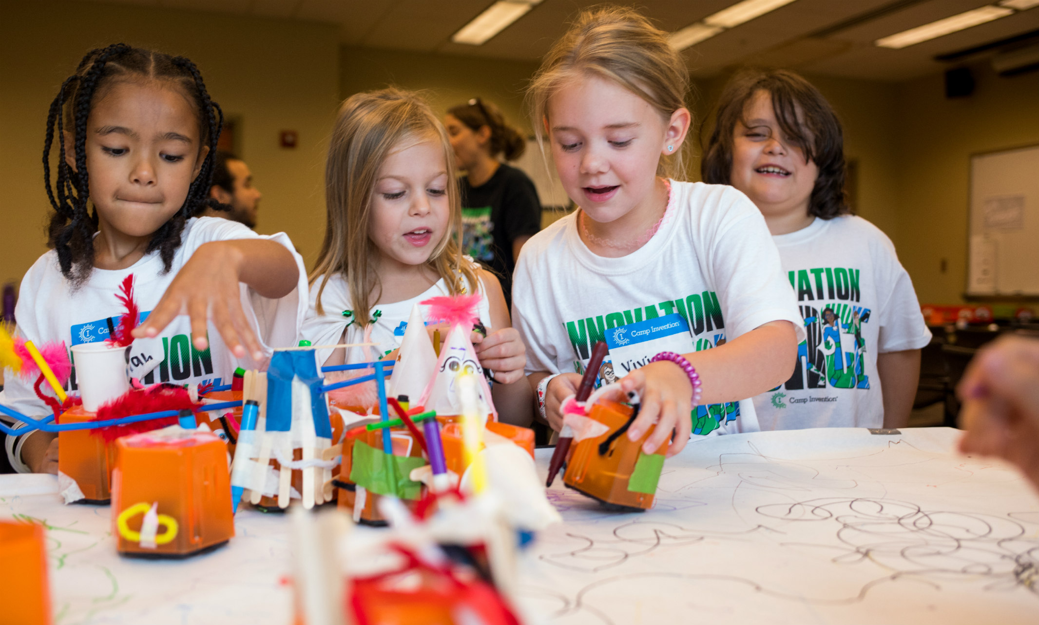 A group of campers creates art with DIY robots