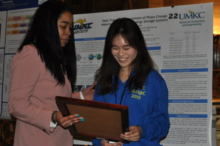female student reviews research findings with state legislator at capitol