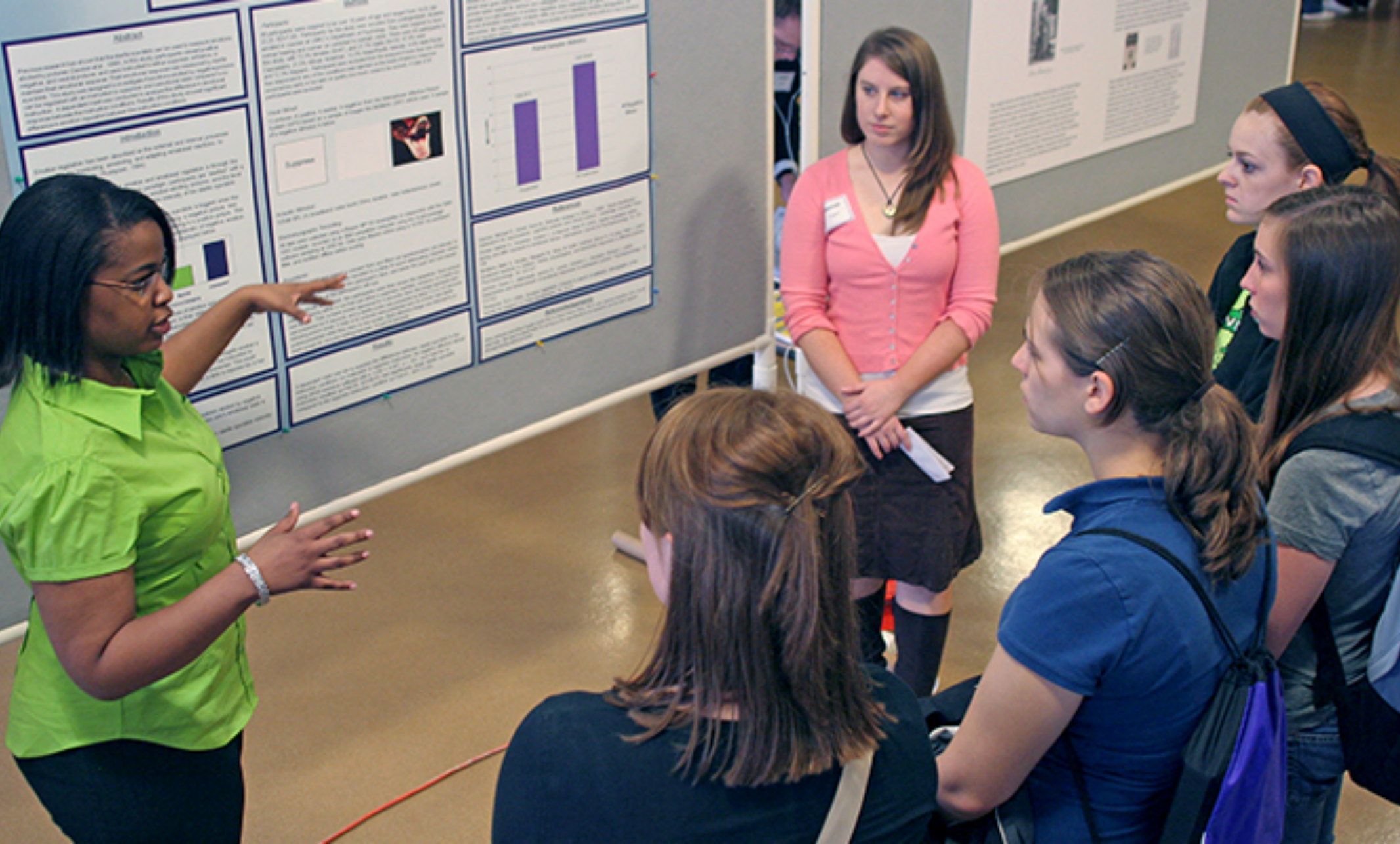 student describes research to group of peers