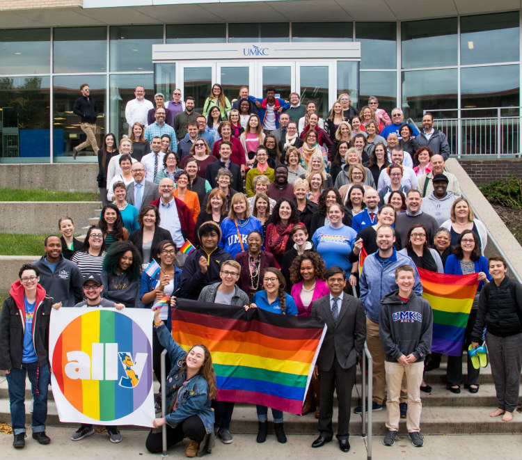 A group photo of dozens of students holding an "Ally" banner at UMKC