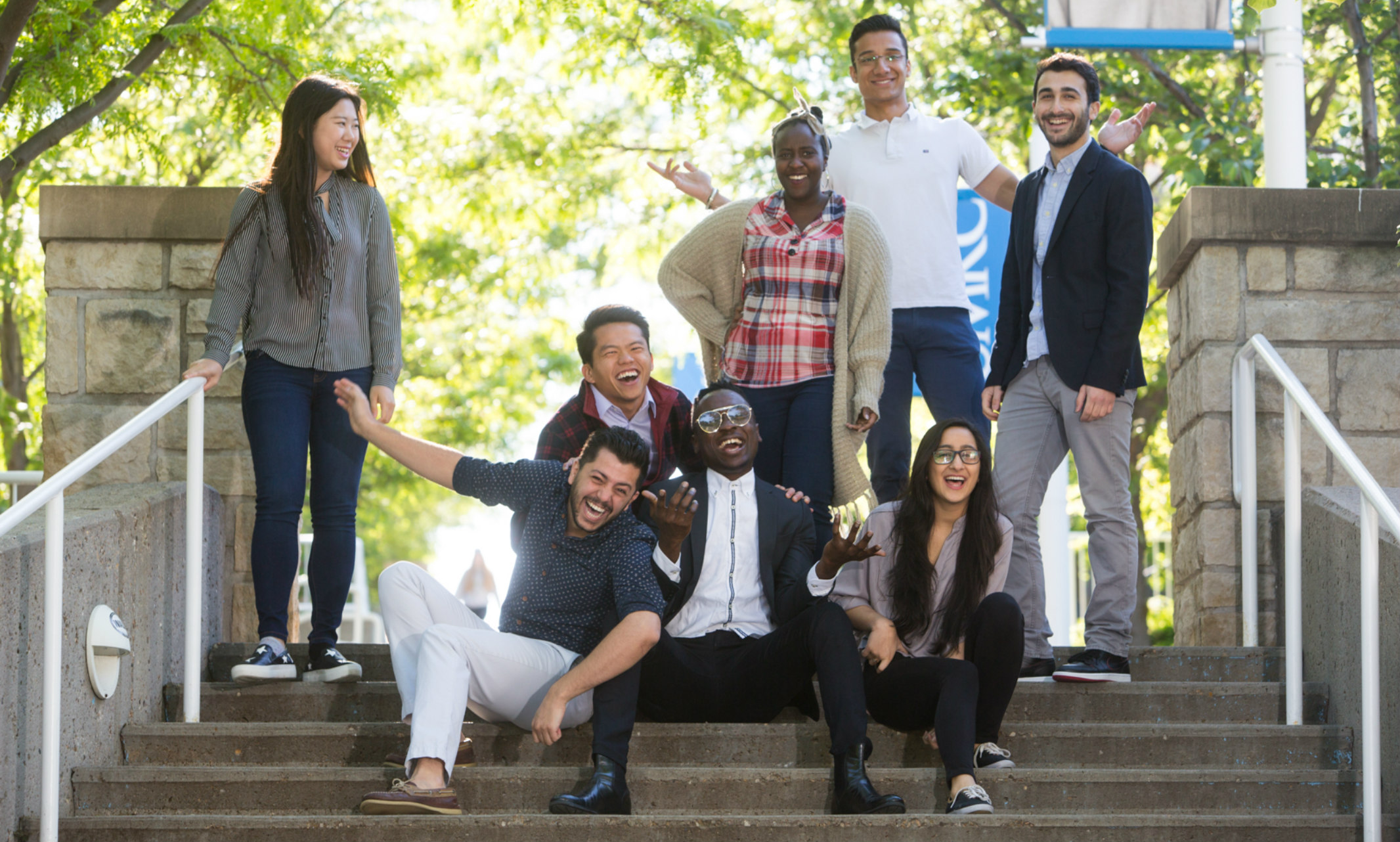 A group of international students from different countries sit on steps on the UMKC campus.