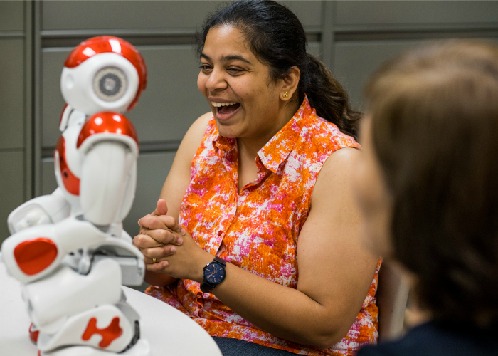 Mayanka-laughs-looking-on-at-a-robot-prototype.png