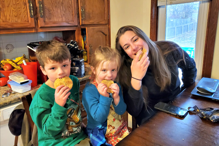 student-and-children-eating-cookies-in-kitchen.jpg