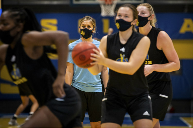 Masked women's basketball students playing