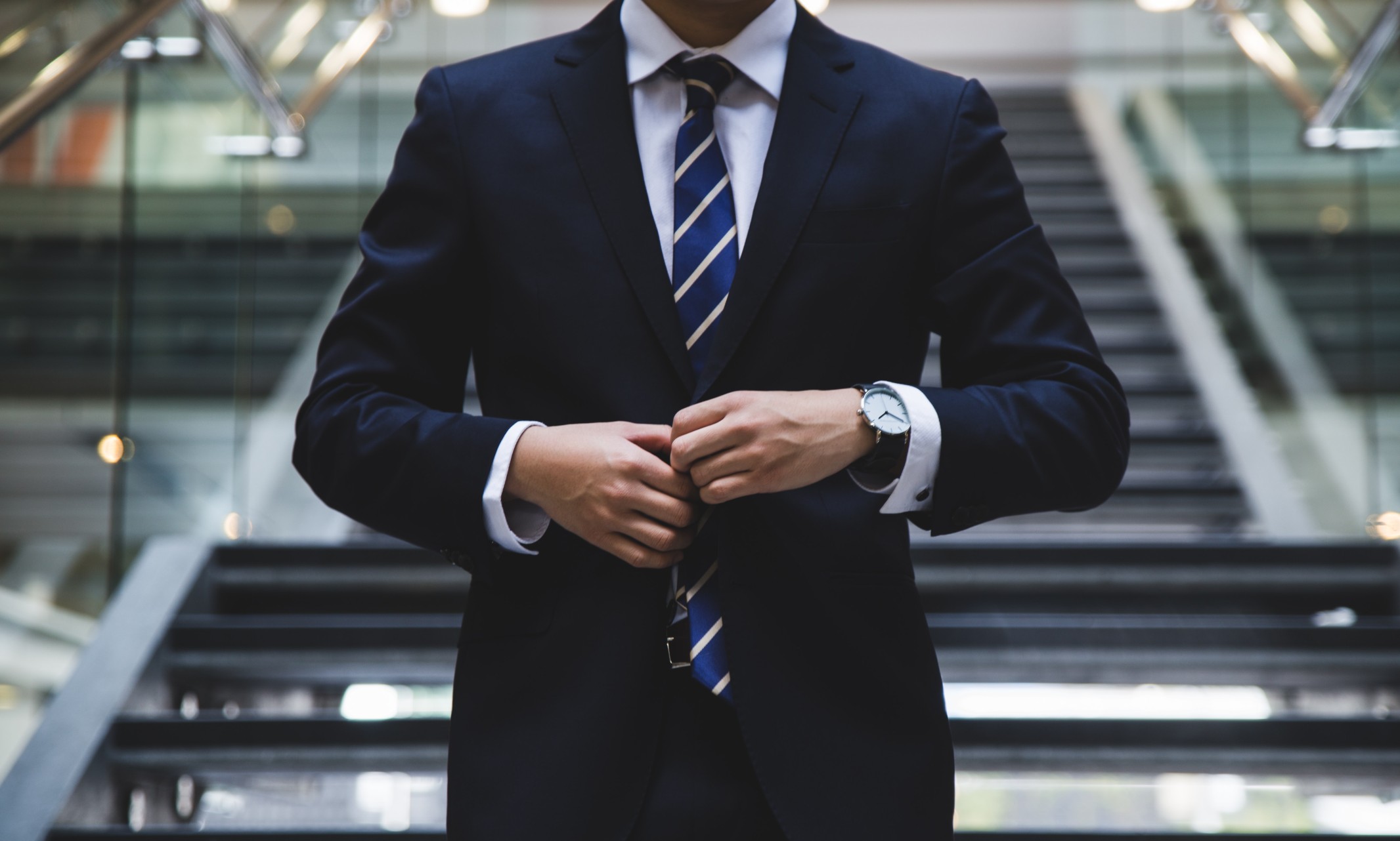 close-up of a man buttoning a suit