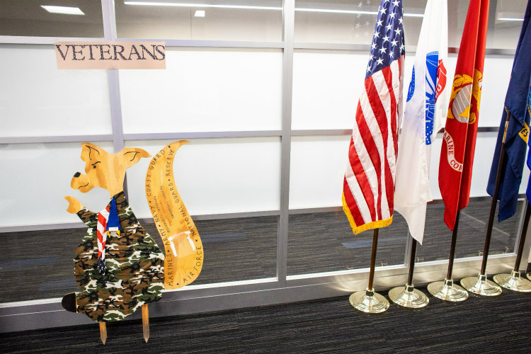 The inside of the At Ease Zone featuring four flags and a sign that reads 'VETERANS'
