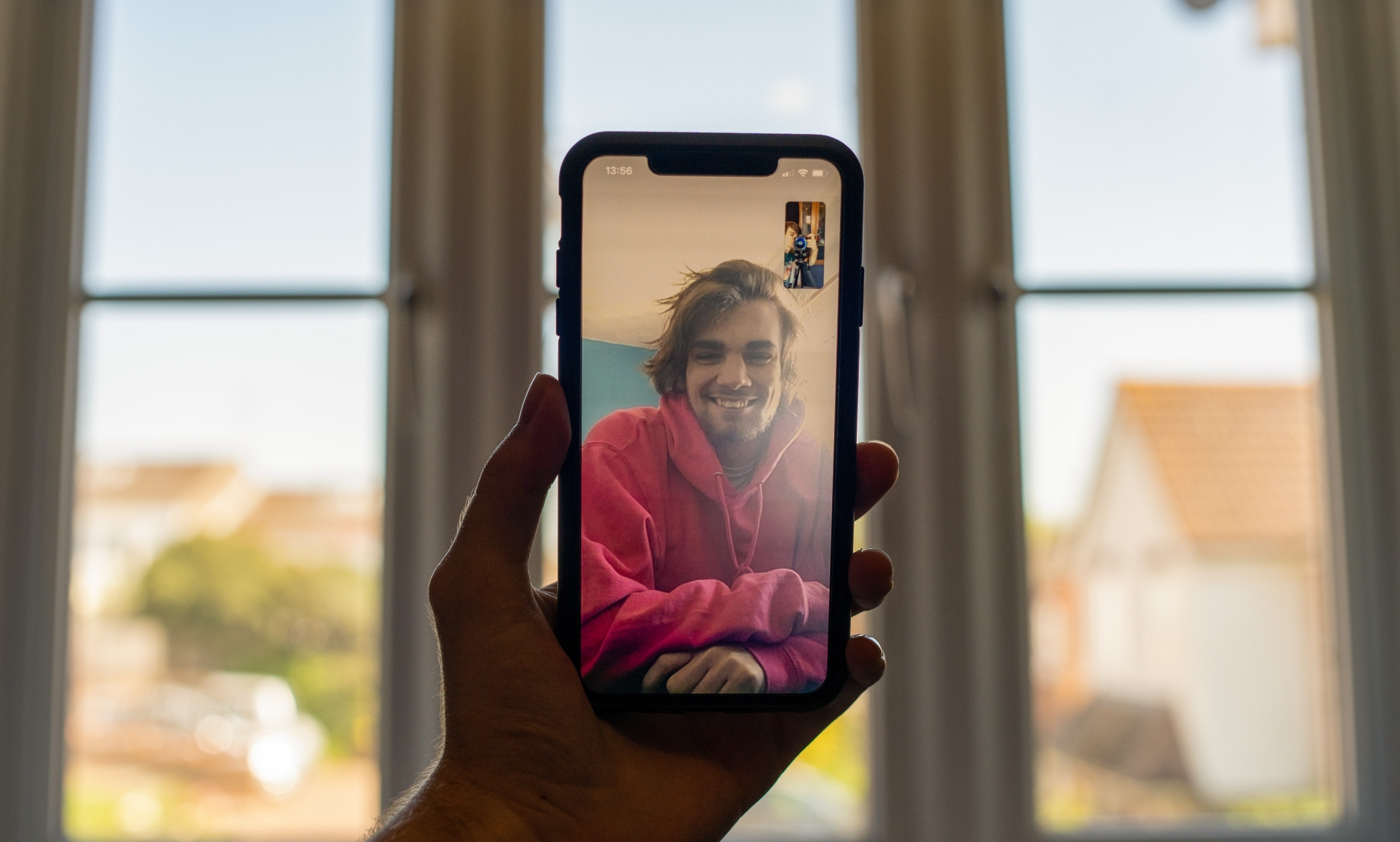 photo of someone holding a phone up while video chatting with a friend