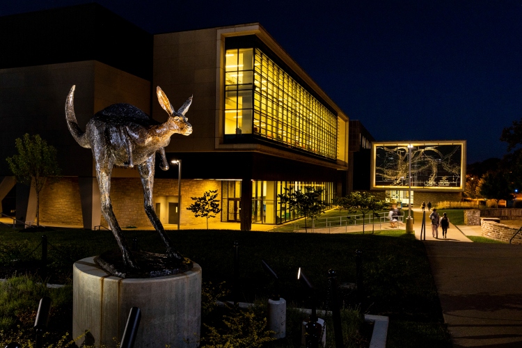 Corbin Roo statue at night with Miller Nichols Library in background