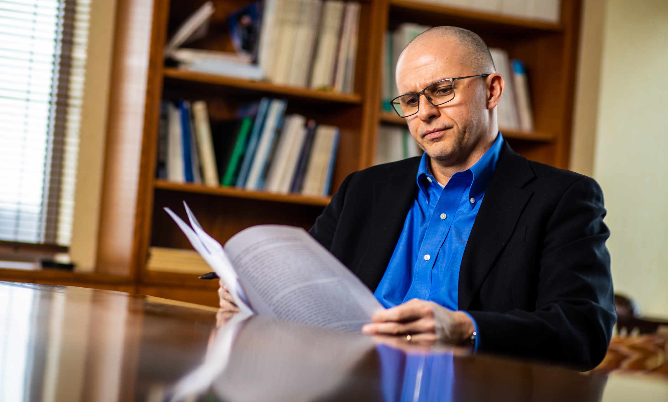 Professor Christopher Garmon perusing research paper in his office