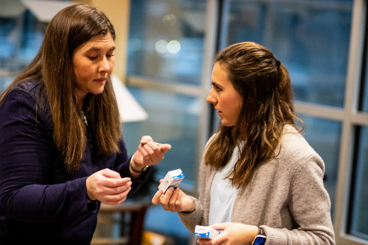 Two females are talking to each other at a growers conference.