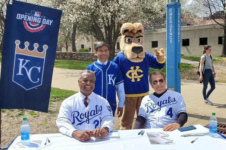Former Royal Frank White, Chancellor Mauli Agrawal, KC Roo and former Royal Greg Pryor stand/sit together and smile at the camera.