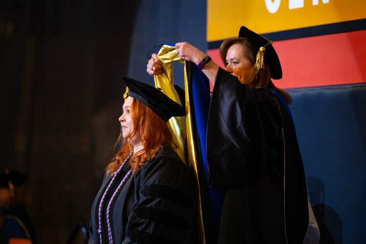 A graduate receives her doctoral hood