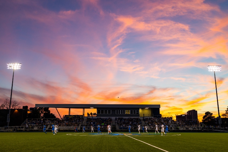 The sun sets behind Durwood stadium as the men's soccer team plays a match