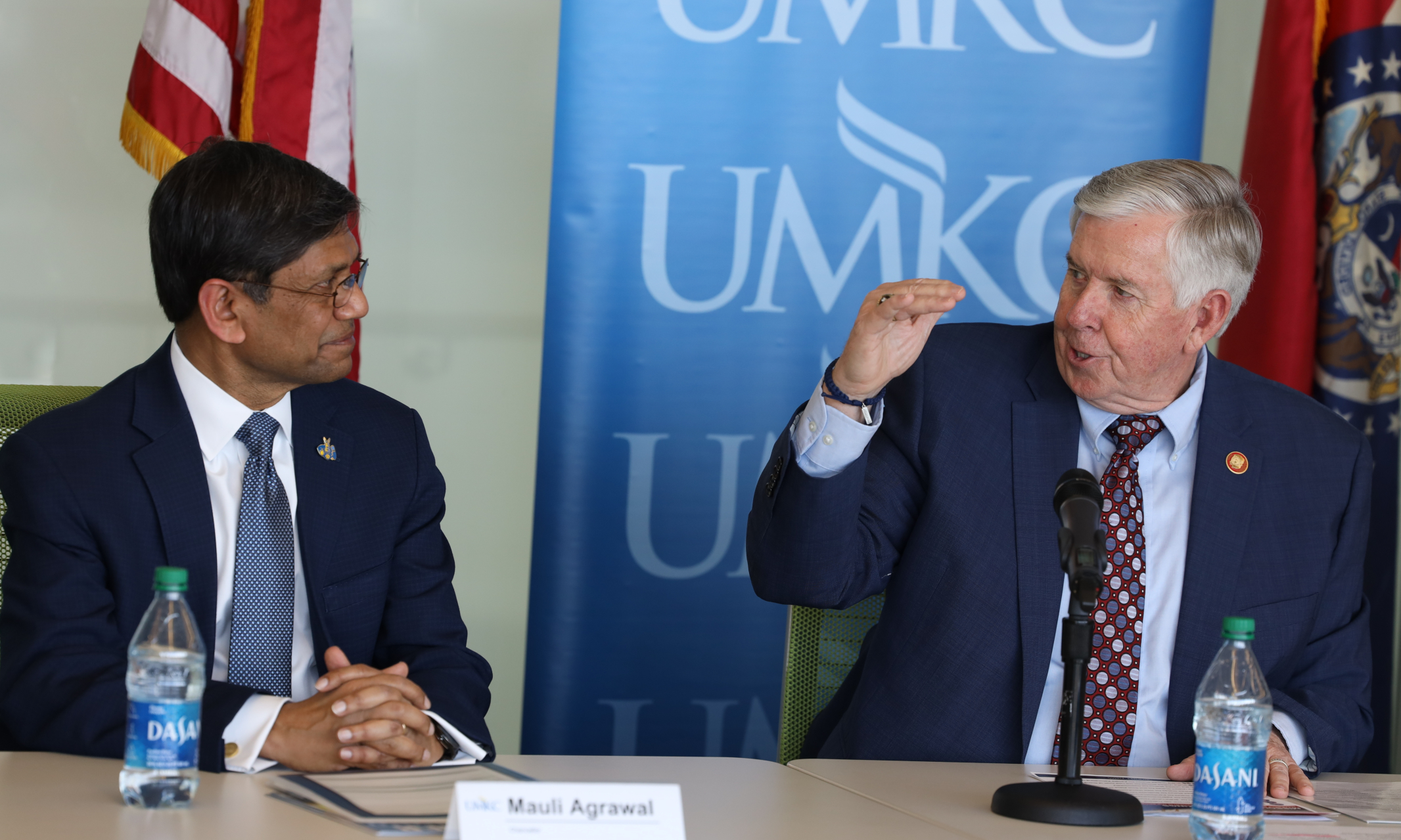 Chancellor C. Mauli Agrawal sits with Governor Mike Parson at a table