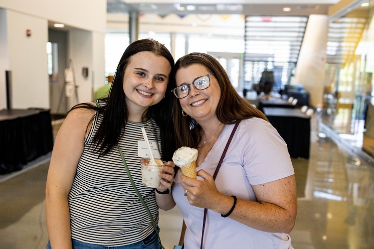 Lily Lefferd, left, stands with her mom Rhonda and they hold ice cream and smile at the camera.