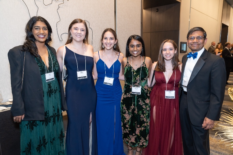 A group of gala attendees smile for a photo with Chancellor Mauli Agrawal