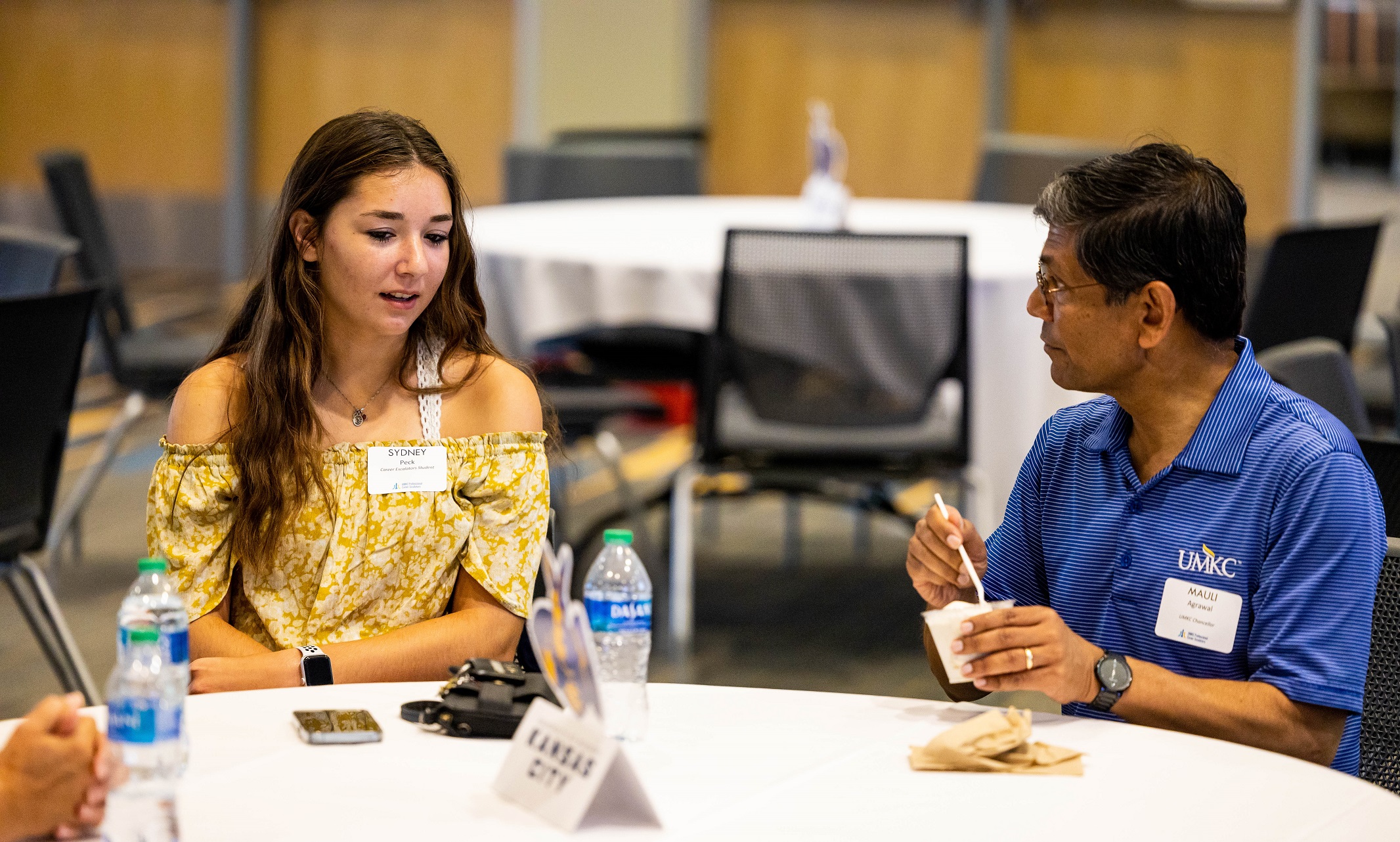 Incoming student Sydney Peck talks with Chancellor Agrawal as they eat ice cream at a table
