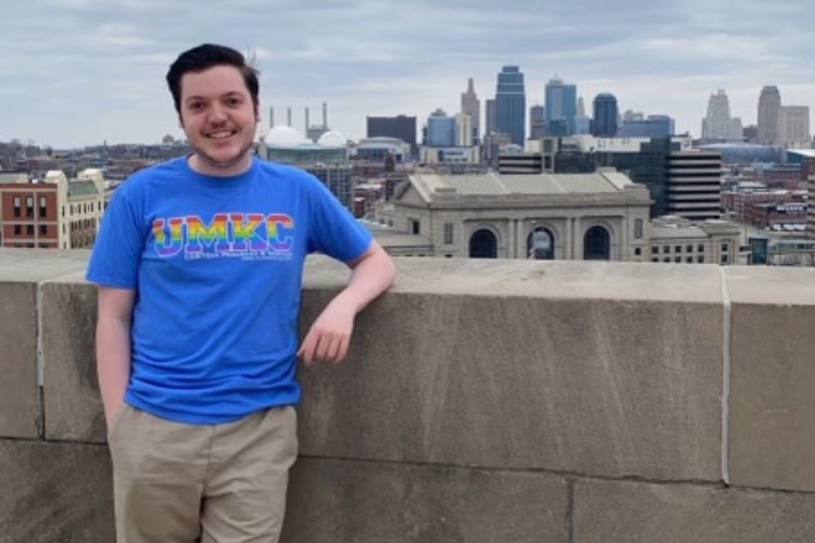 Hunter Meisner, a freshman, stands at the base of the Liberty Memorial with a view of the Kansas City skyline