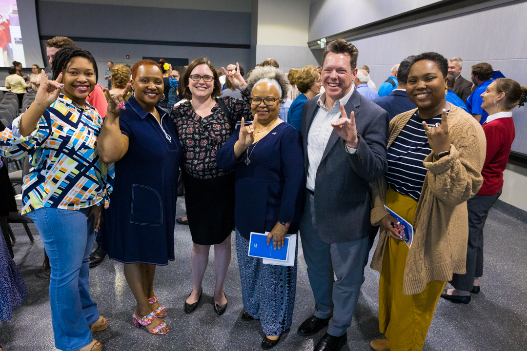 Six UMKC staff members celebrate the awards by making the "roo up" hand signal.