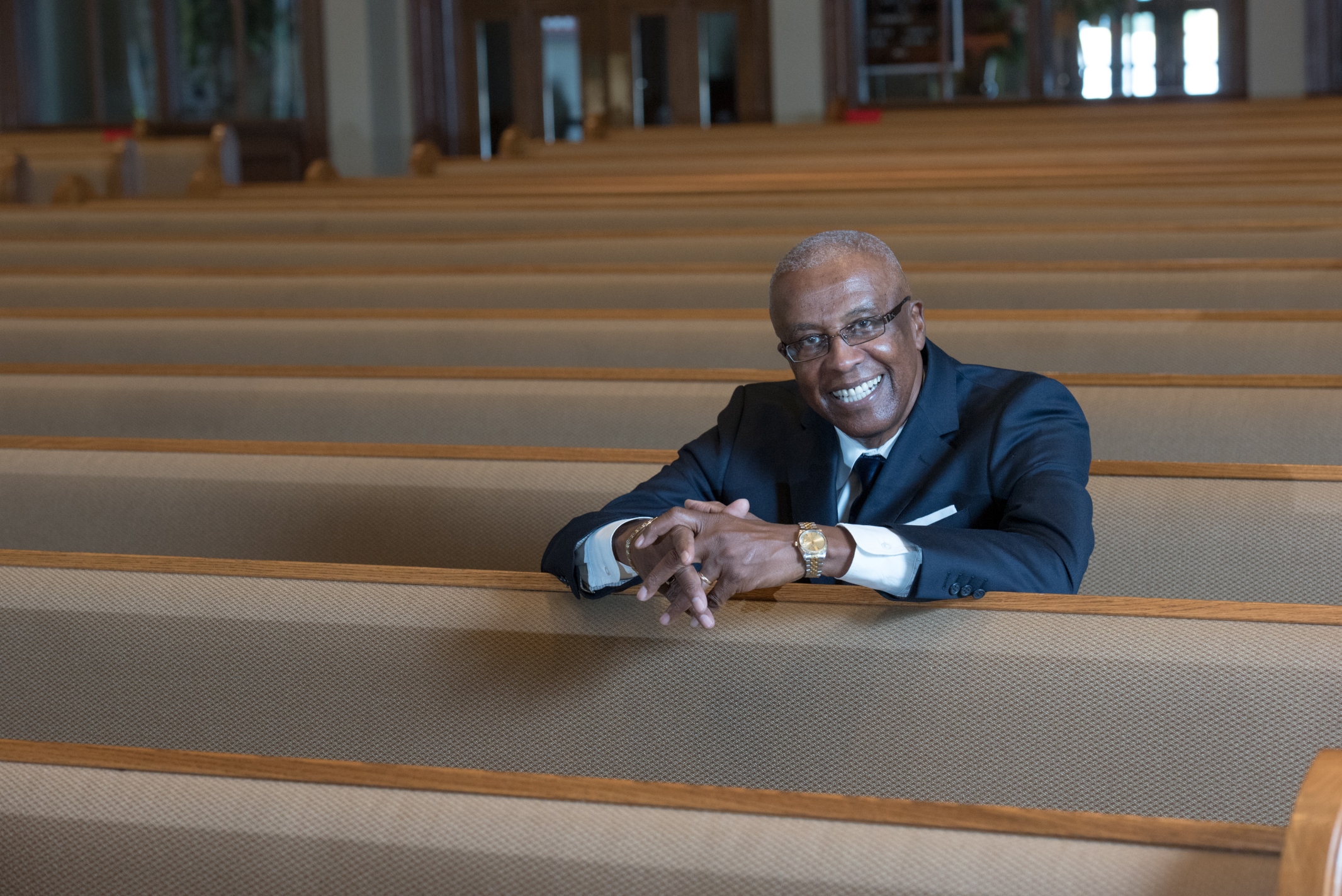Reverend Carl Moore sits in the pews of a church