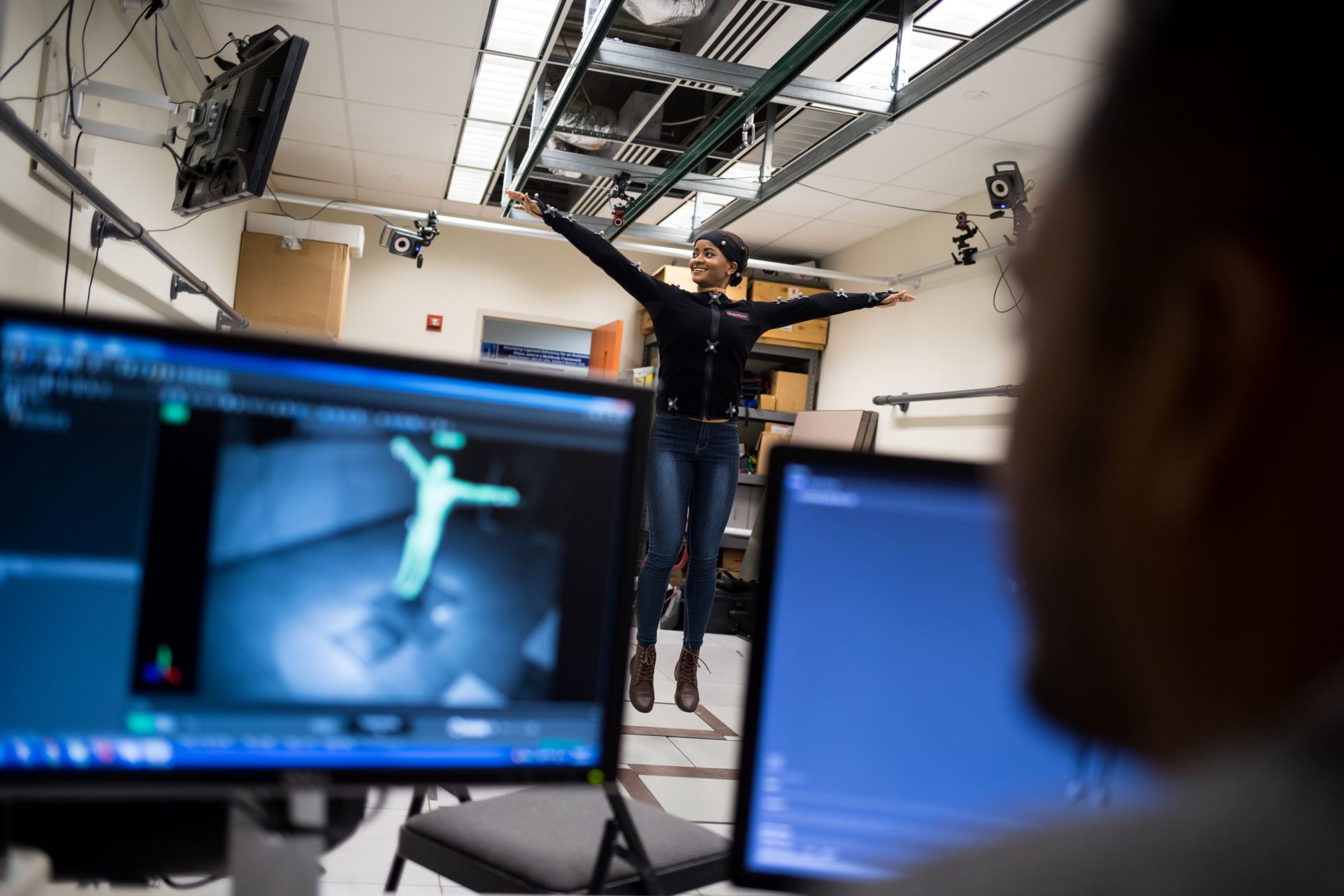 Picture of student in SSE Human Motion Lab with two computer monitors detecting movement.