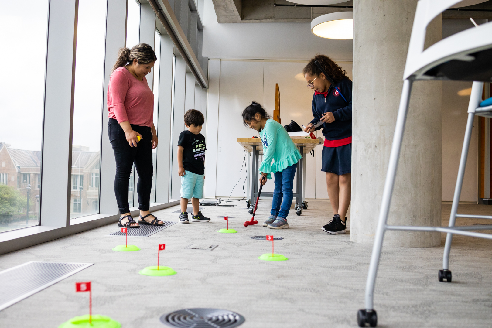 Angelica De La Cruz and her three children play mini golf at the Launch Pad Scholars end of the year event