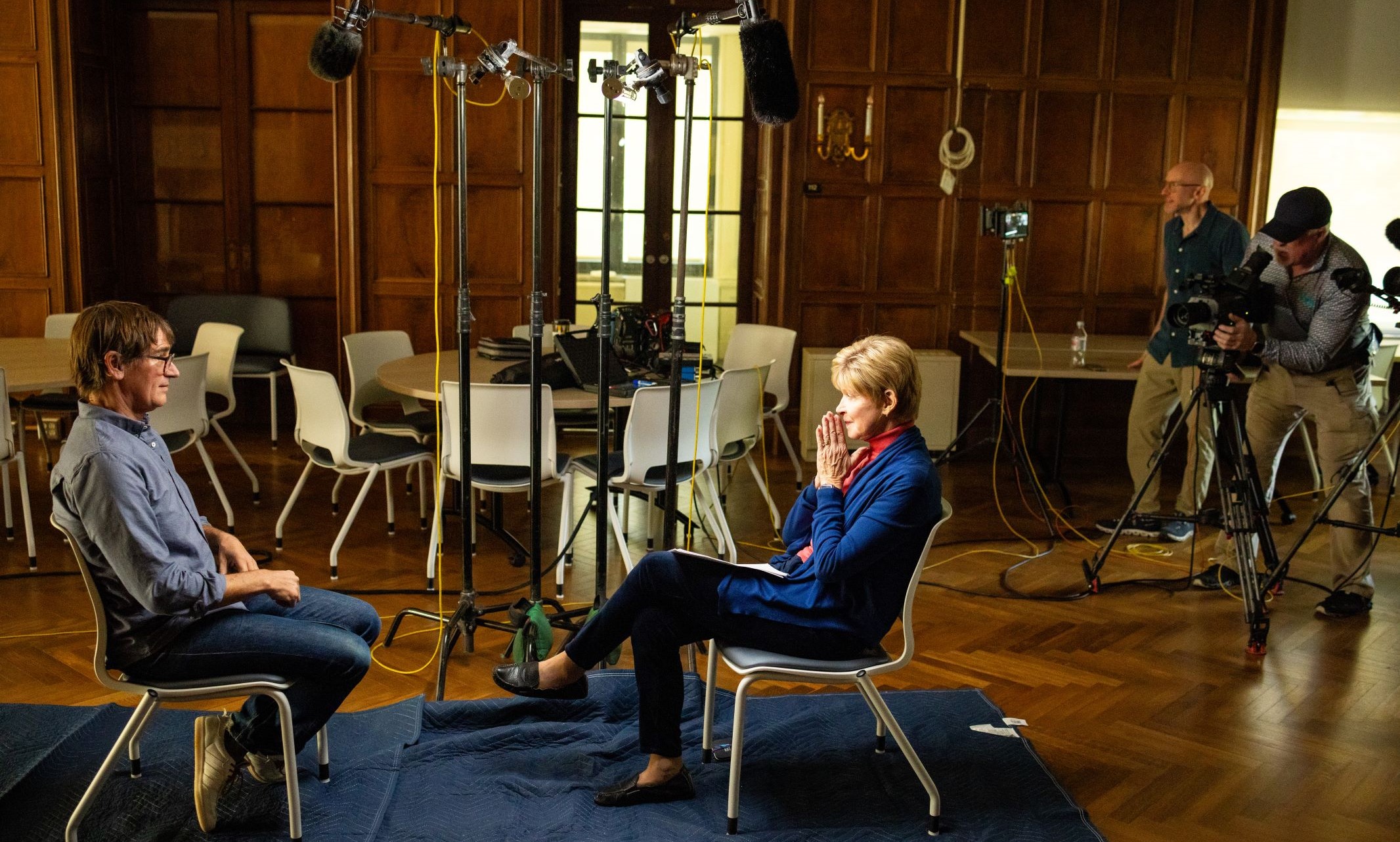 Clancy Martin sits facing CBS reporter Susan Spencer with recording equipment above them and to the right side