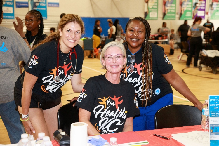 Three smiling people at a health event.