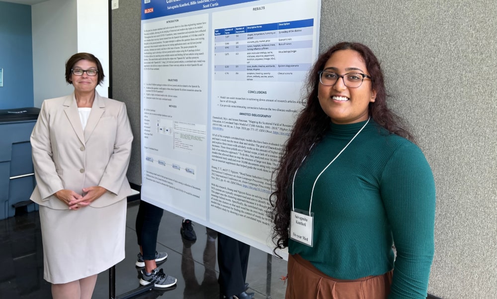 School of Med student Vagmi Kantheti and Statistics Professor Billie Anderson Stand in front of Research Presentation
