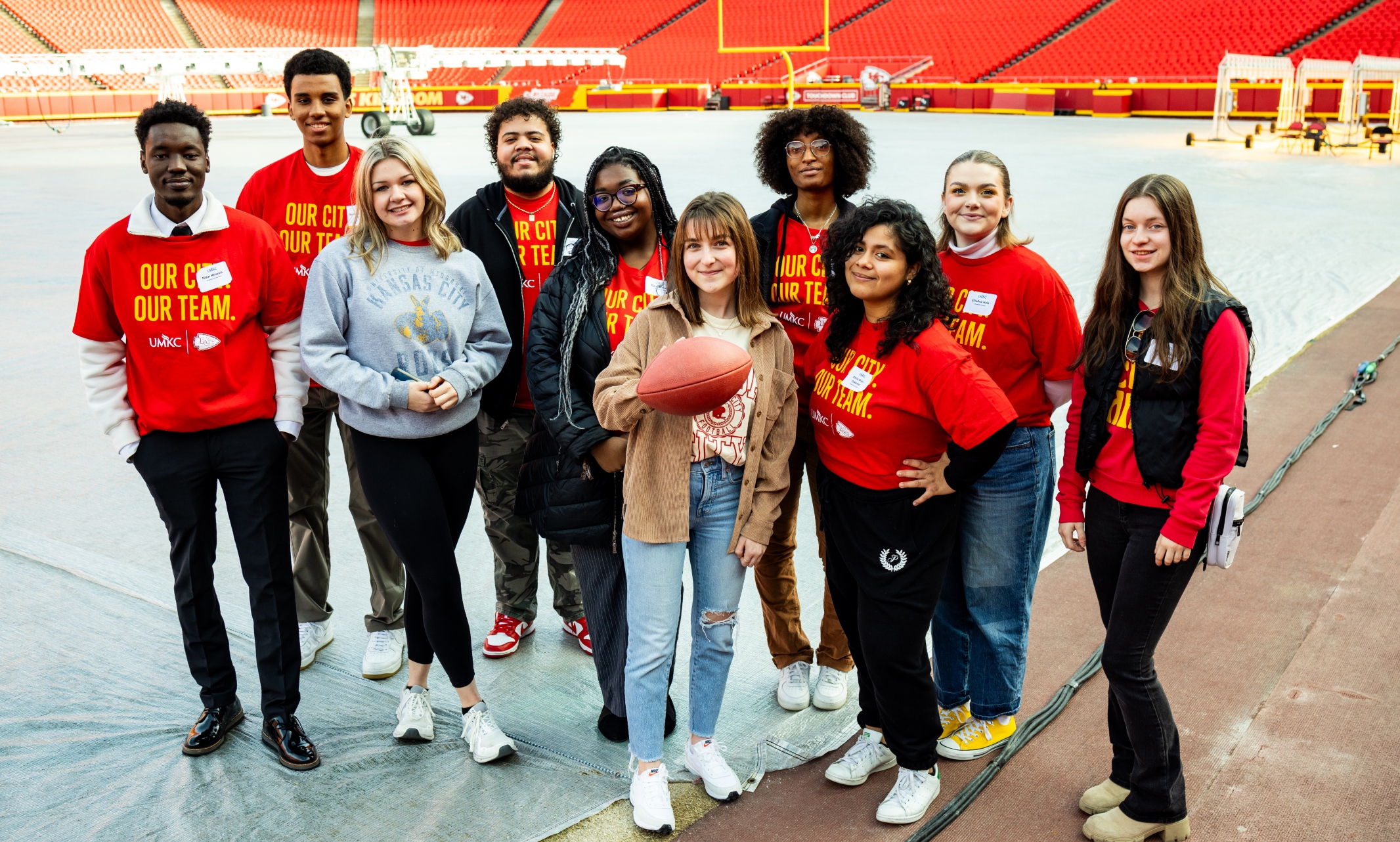 UMKC students pose for group photo on the field at Arrowhead Stadium