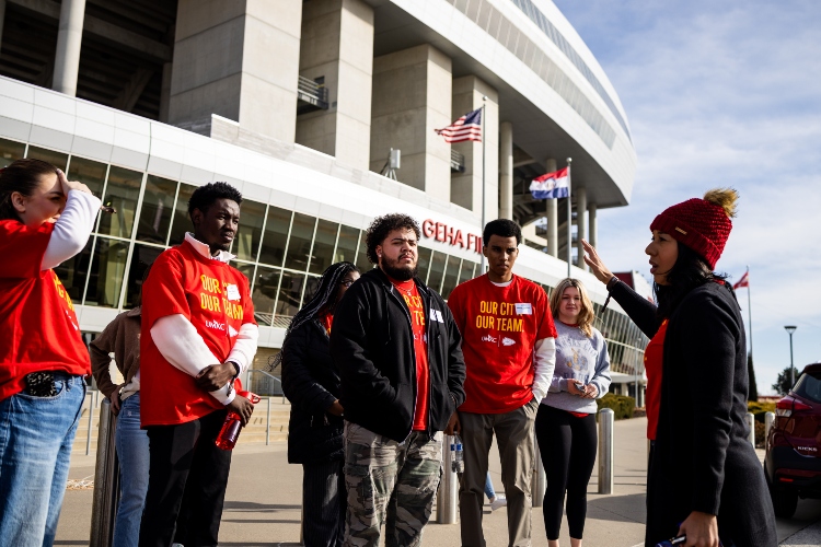 UMKC students standing in front of  Arrowhead stadium listening to the instructor and getting ready for the stadium tour
