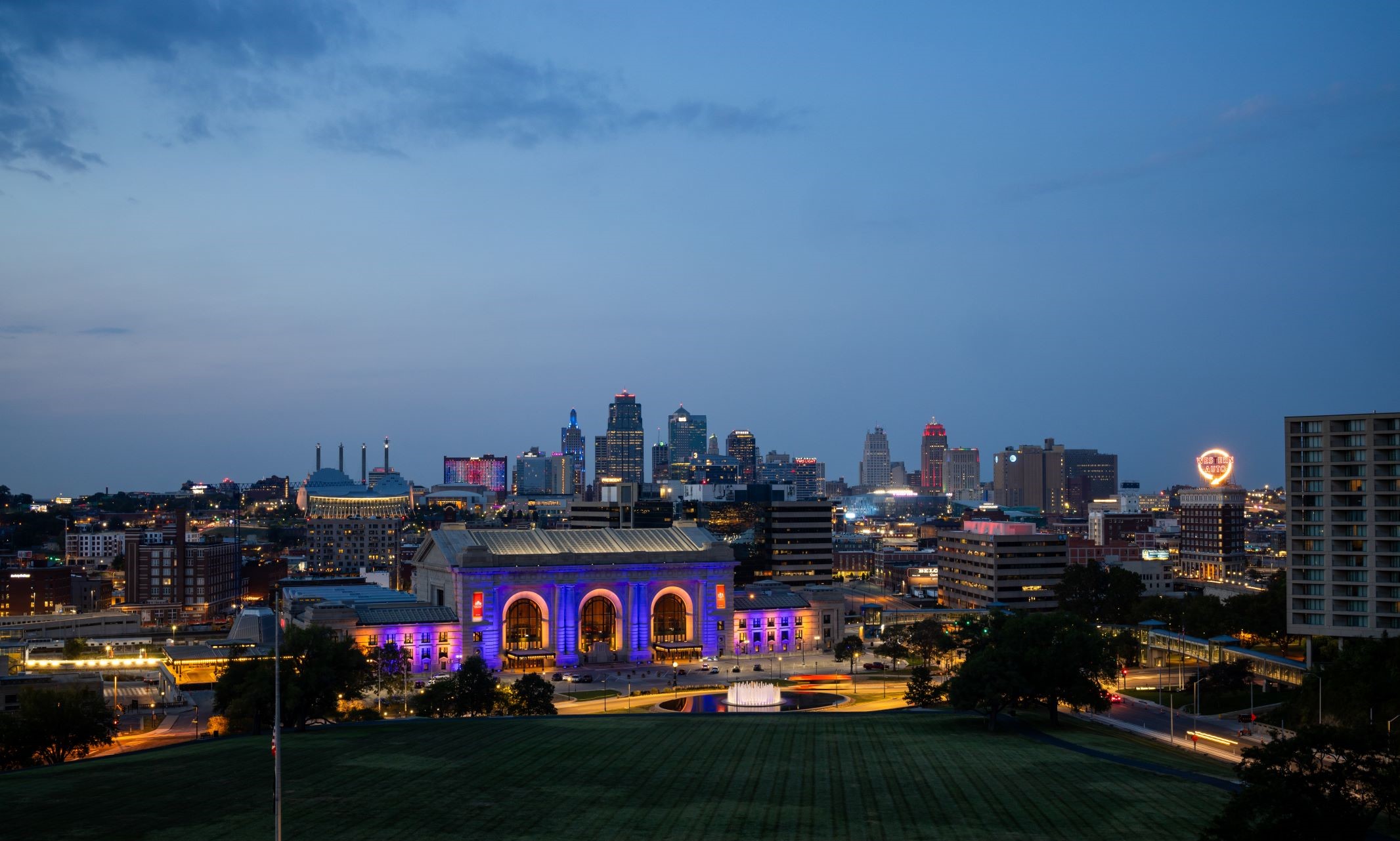 Sunset photo overviewing Kansas City and Union station being lit up in blue and gold