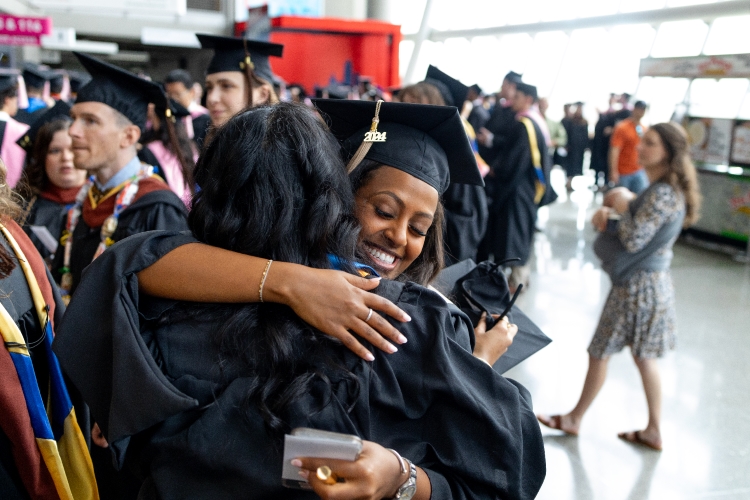 A graduate hugs their family member after the commencement ceremony